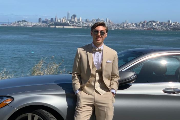 Aydin Oelzturk in a suit in front of a car outside