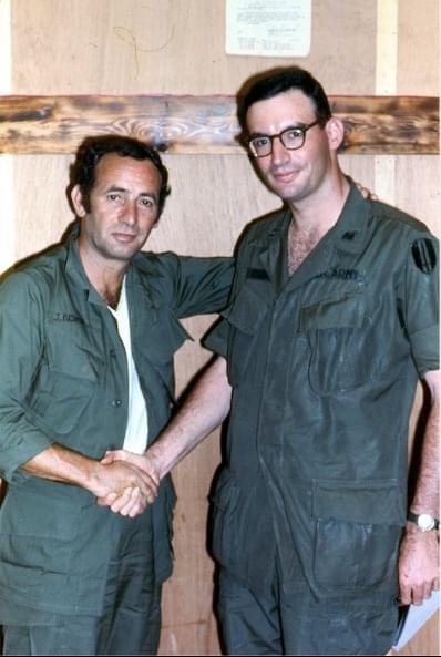 Bruce Stern in army scrubs shaking the hand of a fellow soldier.