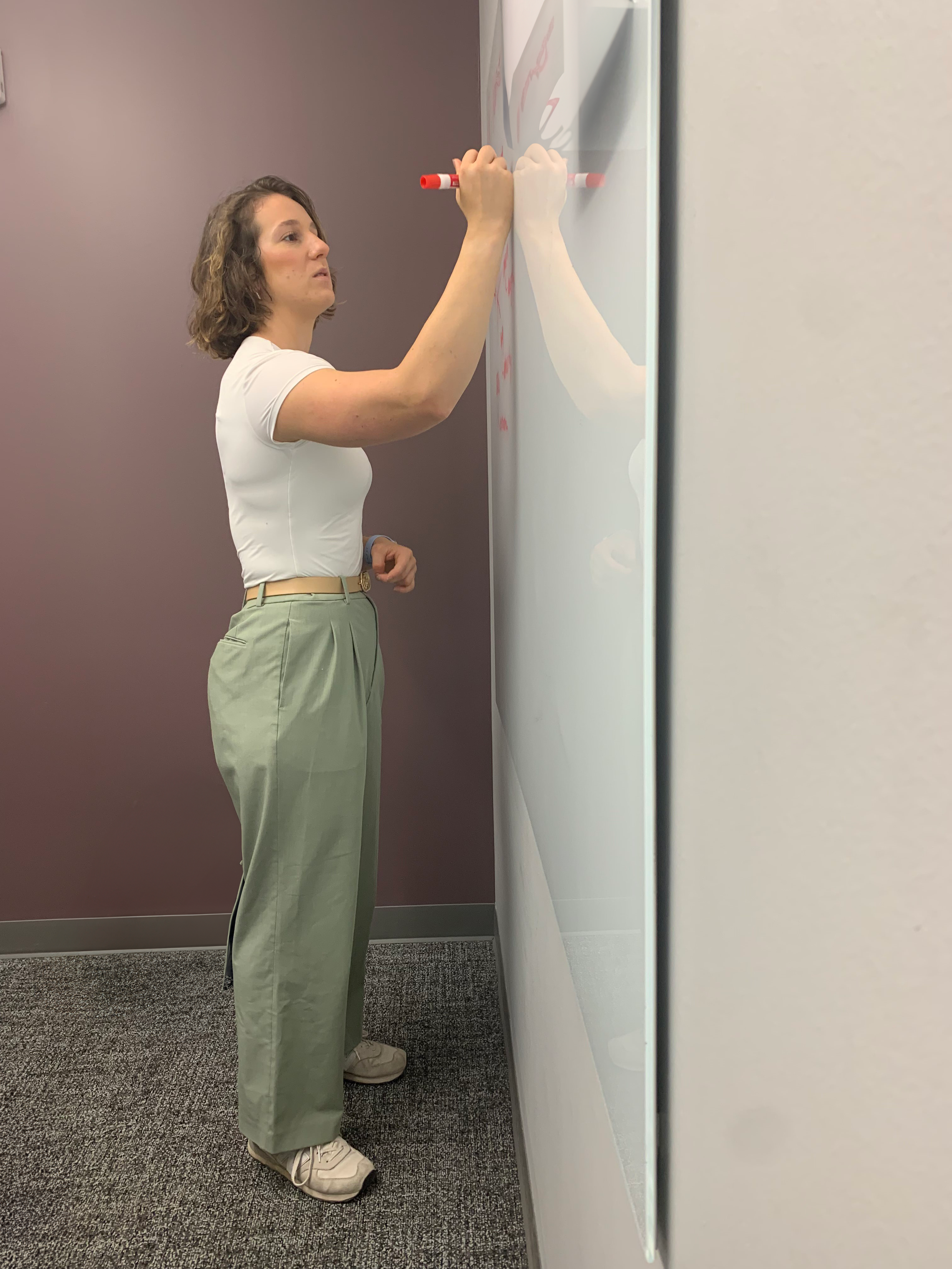 Julianna King drawing on a whiteboard in the School of Kinesiology