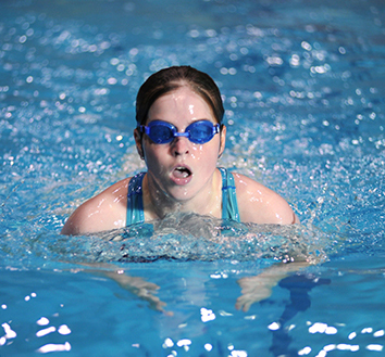 Woman wearing goggles while swimming in a pool