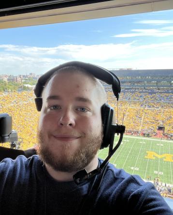 David Woelkers Jr. at a U-M football game in the broadcasting booth