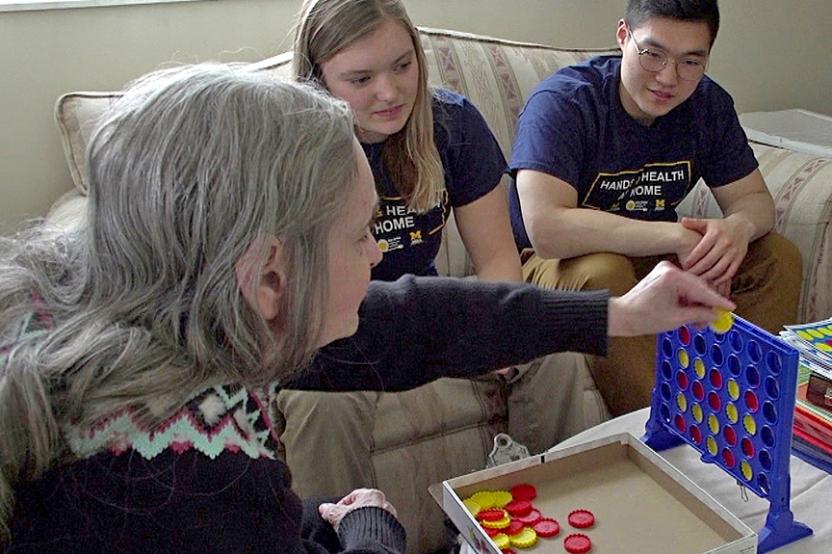 MCL students play a game with a participant to help strengthen hand function
