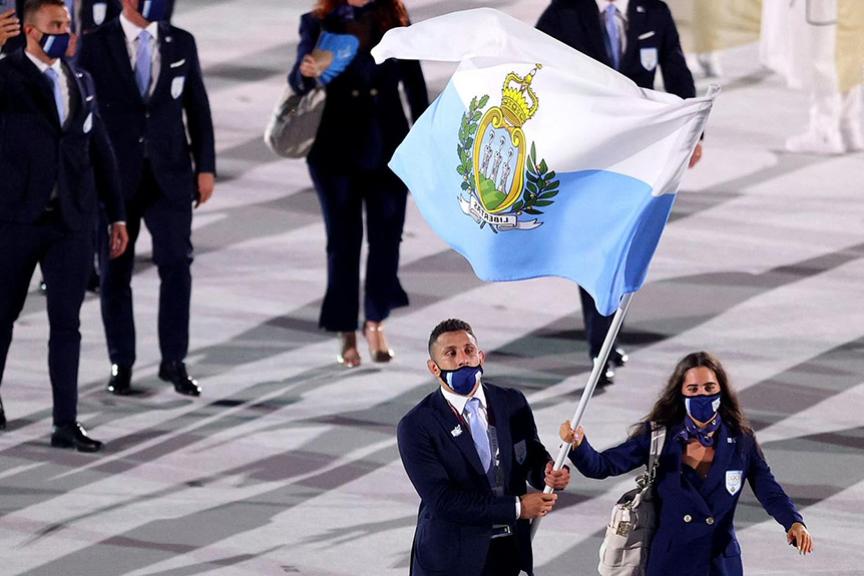 A man and women waving San Marino&#039;s flag while walking