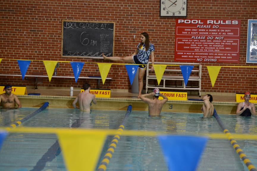 A Kinesiology Community Programs instructor shows swimmers how to do a move.