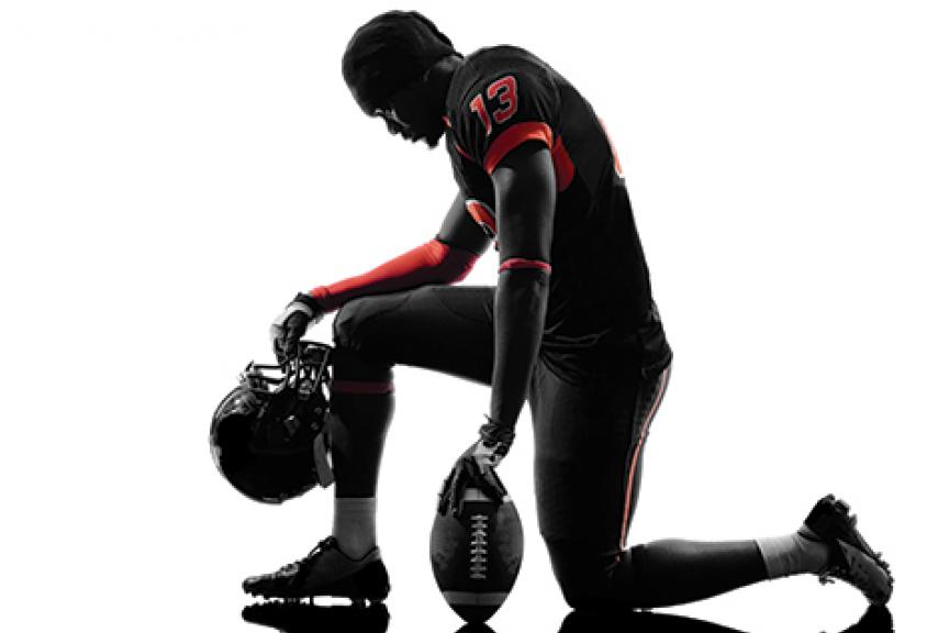 Black football player kneeling