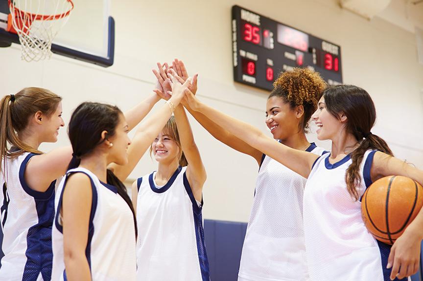 Group of female basketball players high-fiving each other