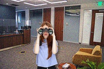 young woman with binoculars in the student services office