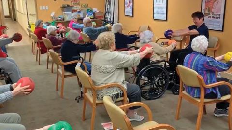 Dr. Chen (right) leads senior citizens in some light exercise