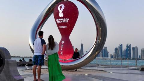 Two people standing in front of a countdown clock in Qatar